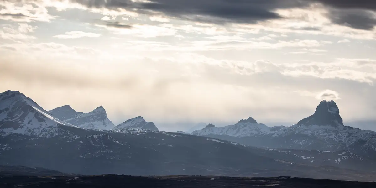 Sunset light over jagged peaks and plains at Glacier National Park, Montana